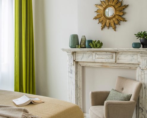 Marble fireplace and cozy beige reading chair