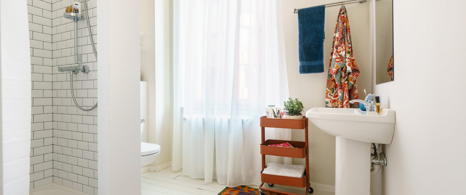 Private bathroom with white flooring and rust accents