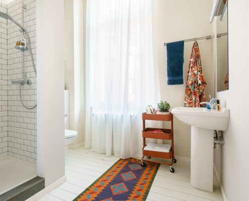 Private bathroom with white flooring and rust accents