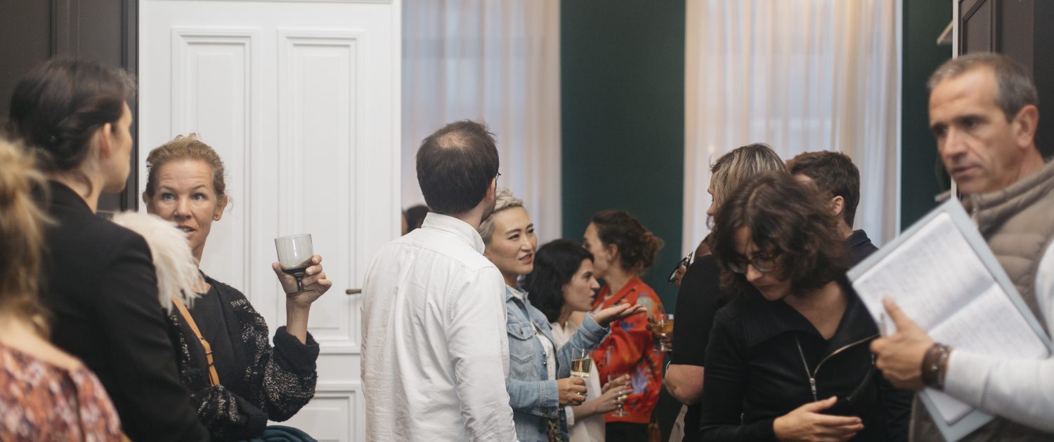 Young adults holding drinks for opening night at Morton Place Louise