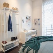 Clothes rack across from bed