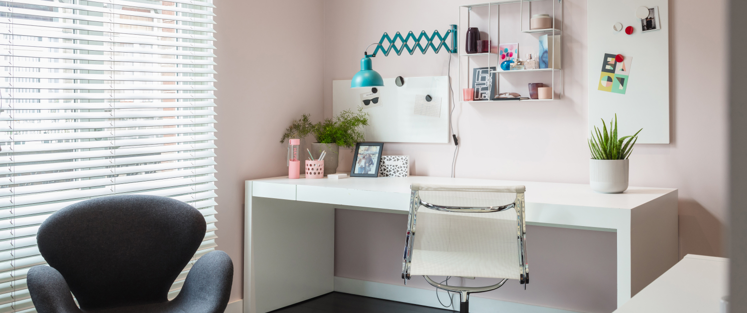 Pink wall with desk next to window
