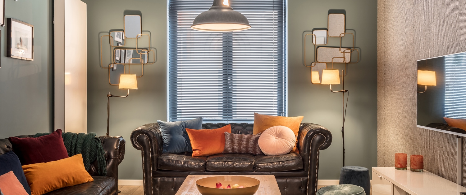 Black chesterfields and green walls with bronze mirror sMorton Place Chatelain Living Room chesterfield couch