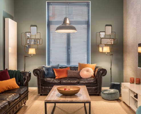 Black chesterfields and green walls with bronze mirror sMorton Place Chatelain Living Room chesterfield couch