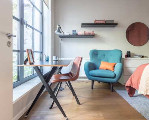 Blue armchair with profile desk and leather chair round mirror