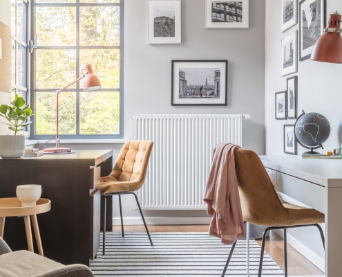 Home office with two desks and two gold velour chairs