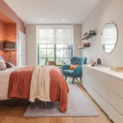 Room 1 orange wall and bed and blue chair