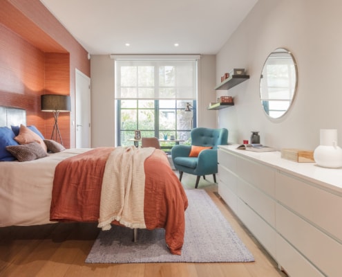 Room 1 orange wall and bed and blue chair