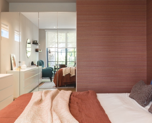 Bedroom with mirrored closet space and spectacular wallpaper