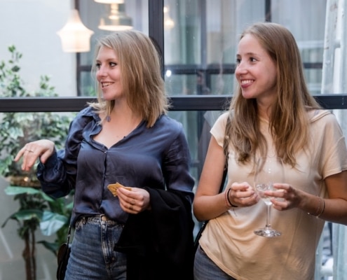 Jeune Femmes souriantes avec un verre a la main en soirée organisée a Bruxelles