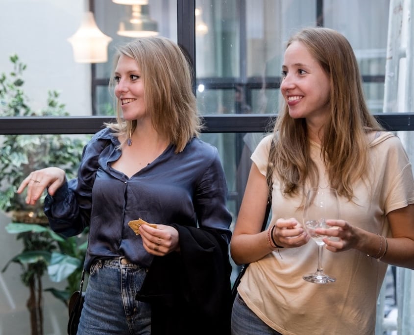 Jeune Femmes souriantes avec un verre a la main en soirée organisée a Bruxelles